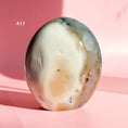 Load image into Gallery viewer, White and grey agate freeform with large white inclusion and black speckles throughout set on a soft pink background.
