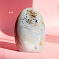 Load image into Gallery viewer, White agate freeform with soft grey inclusions and brown-black speckles on a pale pink background.