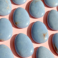 Load image into Gallery viewer, Twelve angelite worry stones are arranged in a row, filling the screen.