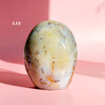 Load image into Gallery viewer, Ivory agate freeform with black speckles and white inclusions set on a soft pink background.