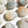 Cargar la imagen en la vista de la galería, Nine agate hearts with quartz inclusions lay scattered on a white background.