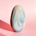 Load image into Gallery viewer, Soft gray agate freeform with many white and brown inclusions on a soft pink background. 
