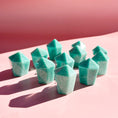 Load image into Gallery viewer, Eleven teal amazonite towers stand in the center of the image with pale pink foreground and darker pink background. 
