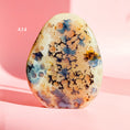 Load image into Gallery viewer, Orange-brown agate freeform with large flower inclusions and black bubbles set on a pale pink background. 
